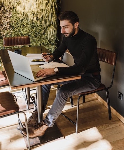 A man working on a computer sitting down at a table